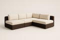 Sofá esquinero modular de mimbre marrón con cojines color crema