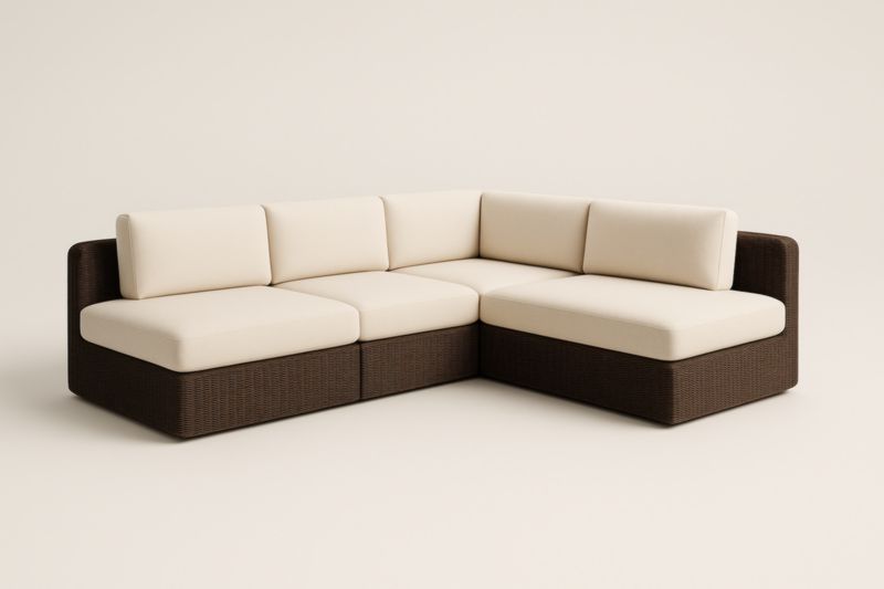 Sofá esquinero modular de mimbre marrón con cojines color crema